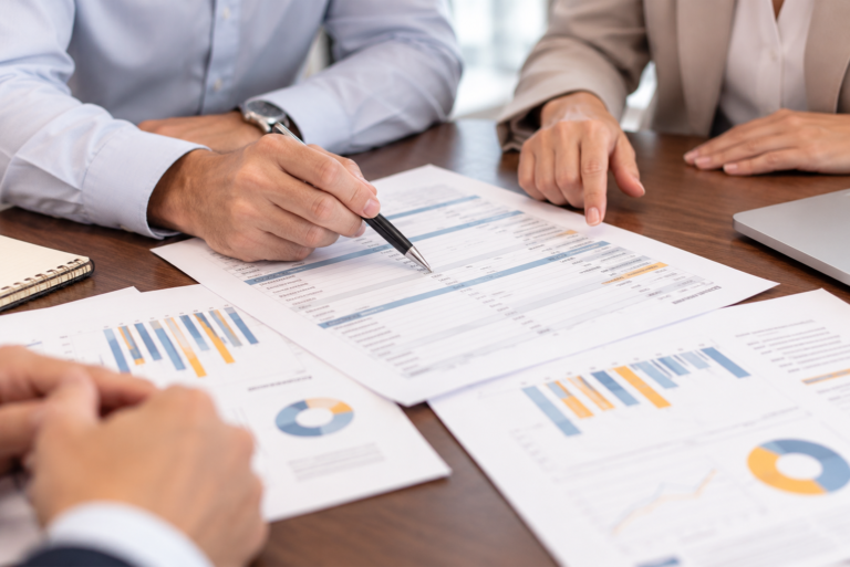 Business professionals reviewing financial statements and documented EBITDA adjustments